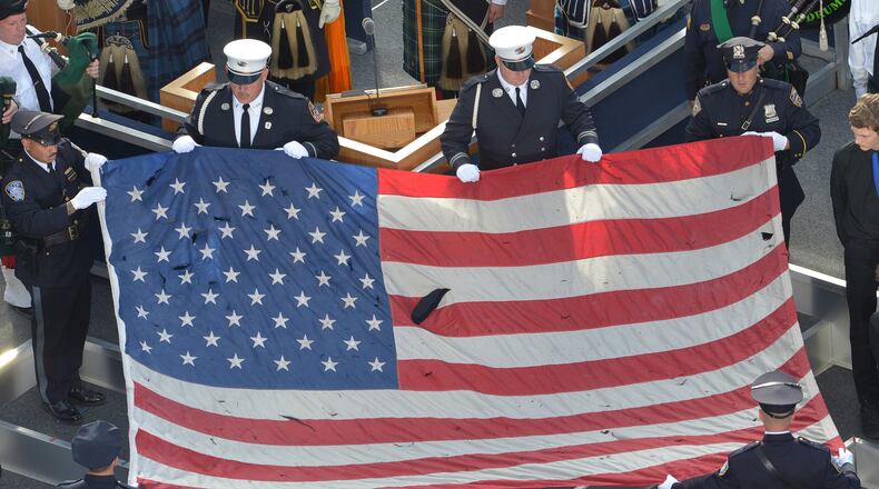 Pictured is a U.S. flag recovered from the 9/11 attacks is displayed by New York City Police officers and firefighters during the ceremony marking the 10th anniversary of the terrorist attack in 2011. In the September 11, 2001 attacks, Al-Qaeda hijackers crashed passenger planes into the World Trade Center in New York and the Pentagon in Washington, while a fourth jet crashed in Shanksville, Pennsylvania. (Mladen Antonov/AFP/Getty Images/TNS)