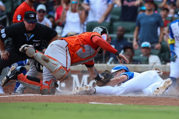 Baltimore Orioles catcher Gary Sánchez, center, tags out Atlanta Braves' Matt Olson, right, at the plate in the fourth inning of a baseball game against the Atlanta Braves, Saturday, July 5, 2025, in Atlanta. (AP Photo/Colin Hubbard)