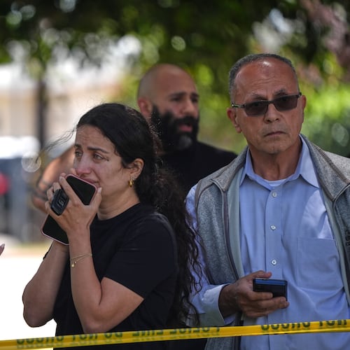 People stand behind police tape at the scene of a shooting outside the Islamic Center of San Diego Monday, May 18, 2026, in San Diego. (AP Photo/Gregory Bull)
