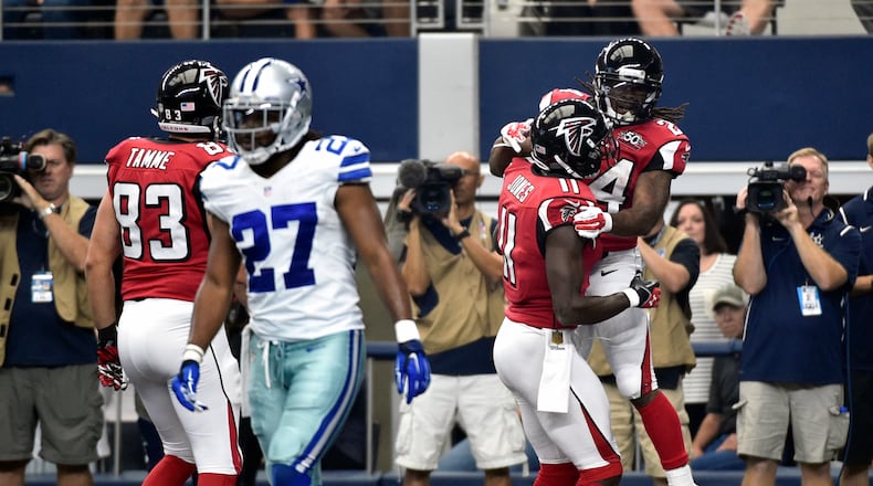 Dallas Cowboys free safety J.J. Wilcox (27) walks away as Atlanta Falcons' Jacob Tamme (83) and Julio Jones (11) celebrate with Devonta Freeman (24) after Freeman scored a touchdown in the first half of an NFL football game on Sunday, Sept. 27, 2015, in Arlington, Texas. (AP Photo/Michael Ainsworth)