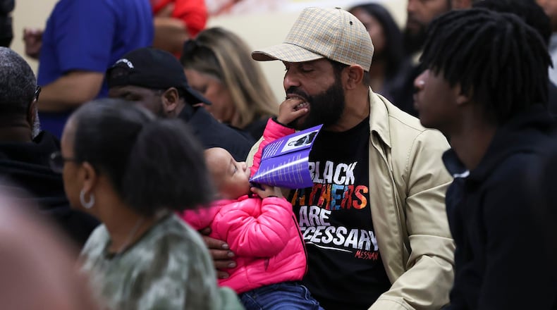 Milton Shabazz with his daughter, Zora. Shabazz is wearing a "Black Fathers are Necessary" shirt while attending a March 13 "Peace Not Guns" community Healing Town Hall meeting at Imhotep Institute Charter High School in Philadelphia. (Heather Khalifa/The Philadelphia Inquirer/TNS)