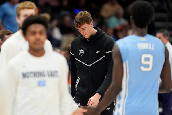 Duke forward Cooper Flagg walks to the bench during the first half of an NCAA college basketball game against North Carolina in the semifinals of the Atlantic Coast Conference tournament, Friday, March 14, 2025, in Charlotte, N.C. Flagg and was injured yesterday. (AP Photo/Chris Carlson)