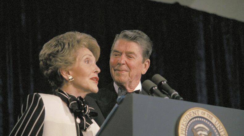 FILE - President Ronald Reagan watches as first lady Nancy Reagan comments from the podium during the White House Correspondents' Association annual dinner on April 23, 1987, in Washington. (AP Photo/Charles Tasnadi, File)
