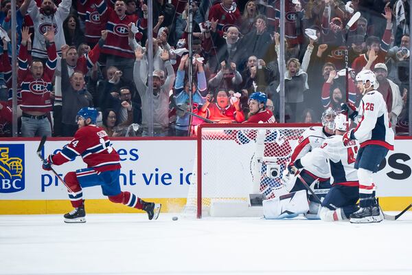 Montreal Canadiens' Nick Suzuki (14) scores against Washington Capitals goaltender Logan Thompson (48) during the second period of Game 3 of a first-round NHL hockey playoff series in Montreal Friday, April 25, 2025. (Christopher Katsarov/The Canadian Press via AP)