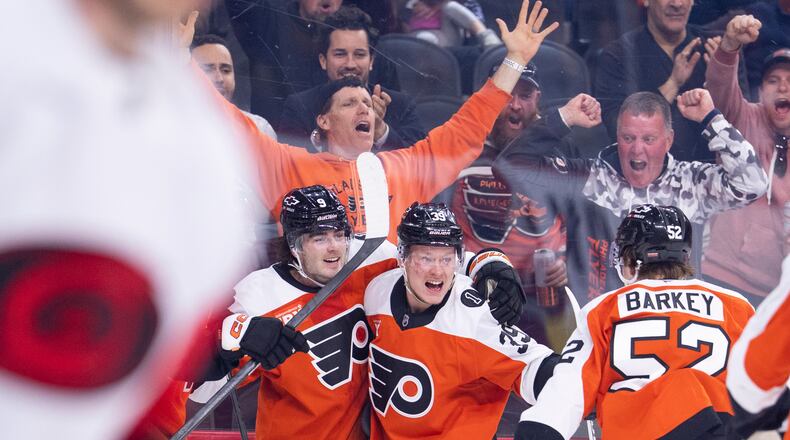 Philadelphia Flyers right winger Matvei Michkov, center, celebrates after his goal with defenseman Jamie Drysdale, left, and center Denver Barkey, right, during the second period of an NHL hockey game against the Carolina Hurricanes, Monday, April 13, 2026, in Philadelphia. (AP Photo/Chris Szagola)