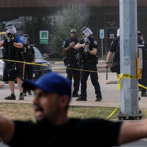 Authorities deploy non-lethan weapons near a demonstration where a man was shot in his vehicle by an ICE officer, Sunday, Sept. 20, 2026, in Austin, Texas. (AP Photo/Joel Angel Juarez)