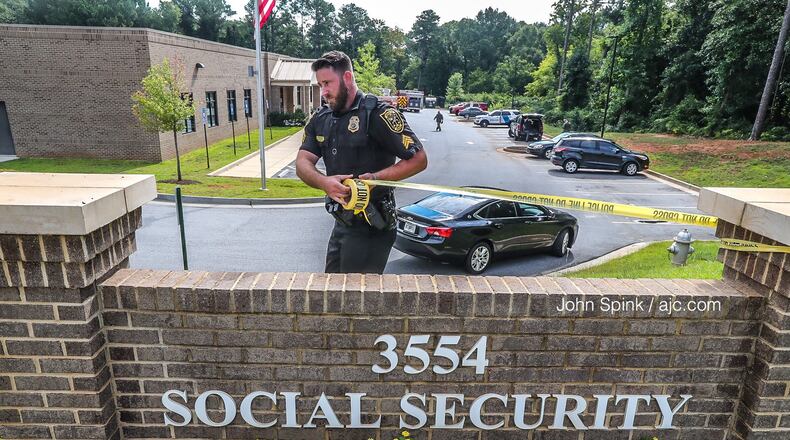 DeKalb police Sgt. J.A. Rifling puts up crime scene tape at the Social Security Administration office.