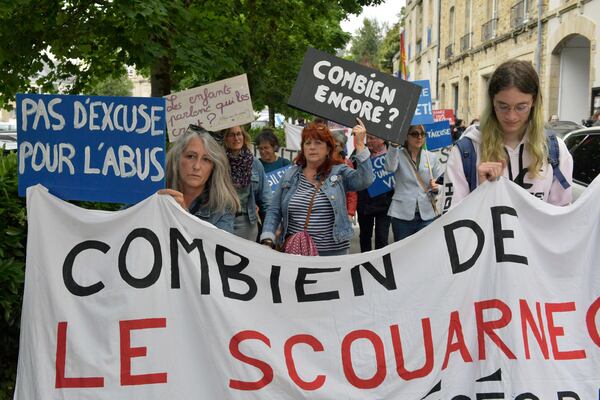 People demonstrate with a banner reading "How many Le Scouarnec" ahead of the verdict in the trial of Joel Le Scouarnec, a 74-year-old former surgeon, accused of raping and sexually assaulting 299 children, Wednesday, May 28, 2025 in Vannes, Brittany, western France. (AP Photo/Mathieu Pattier)