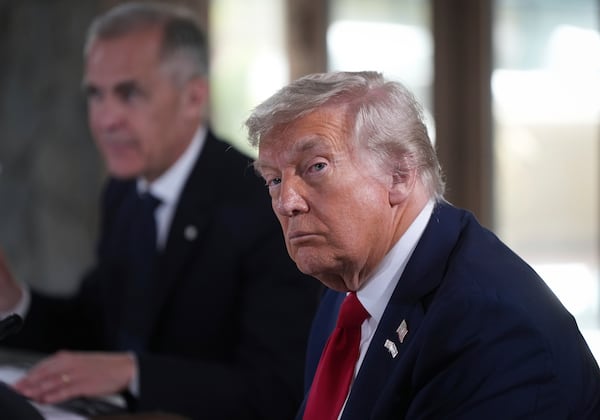 U.S. President Donald Trump, front right, listens to a question being shouted out by a reporter while seated next to Canadian Prime Minister Mark Carney, back left, during working session at the G7 Summit in Kananaskis, Alberta, Canada, Monday, June 16, 2025. (Darryl Dyck/The Canadian Press via AP)