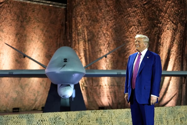 President Donald Trump stands backdropped by an MQ-9 Reaper drone before addressing military personnel at the Al Udeid Air Base, Thursday, May 15, 2025, in Doha, Qatar. (AP Photo/Alex Brandon)