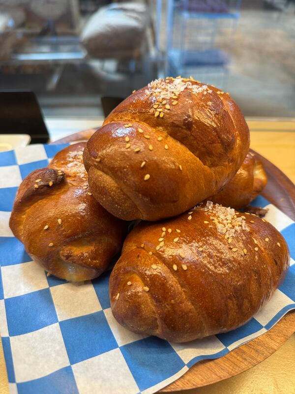 A stack of salt bread rolls on a blue checkerboard paper