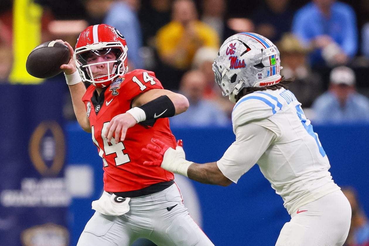 Georgia quarterback Gunner Stockton throws under pressure from Ole Miss linebacker TJ Dottery during the College Football Playoff quarterfinal game Jan. 1, 2026. (Jason Getz/AJC)