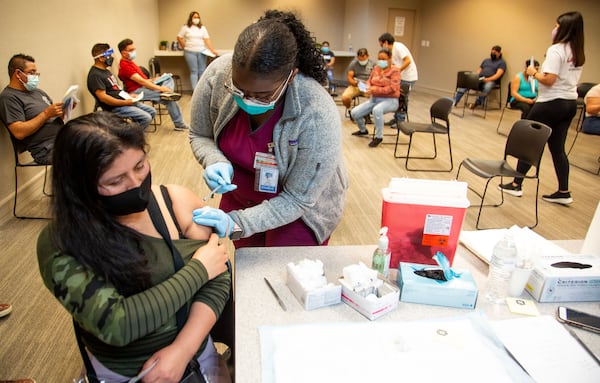 Forth year, Morehouse School medical student Nikk Jonen administers a Covidd Vaccine shot to Rosibel Nava Munivez at the Mexican Consulate in Atlanta Saturday, May 1, 2021. STEVE SCHAEFER FOR THE ATLANTA JOURNAL-CONSTITUTION