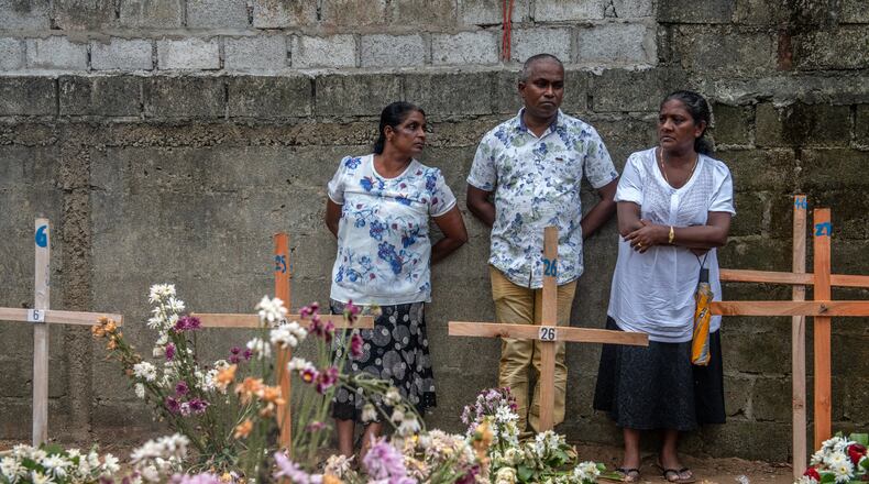 NEGOMBO, SRI LANKA - APRIL 25: People stand behind fresh graves as they attend a funeral for a person killed in the Easter Sunday attack on St Sebastian’s Church, on April 25, 2019 in Negombo, Sri Lanka. At least 359 people were killed and 500 people injured after coordinated attacks on churches and hotels on Easter Sunday. (Carl Court/Getty Images)
