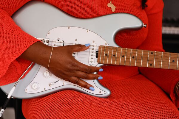 Danielle Ponder plays the guitar in her home studio in Stone Mountain on June 6, 2025. The singer quit her job as a public defender in Rochester, New York, to pursue a music career in Atlanta. (Natrice Miller/AJC)