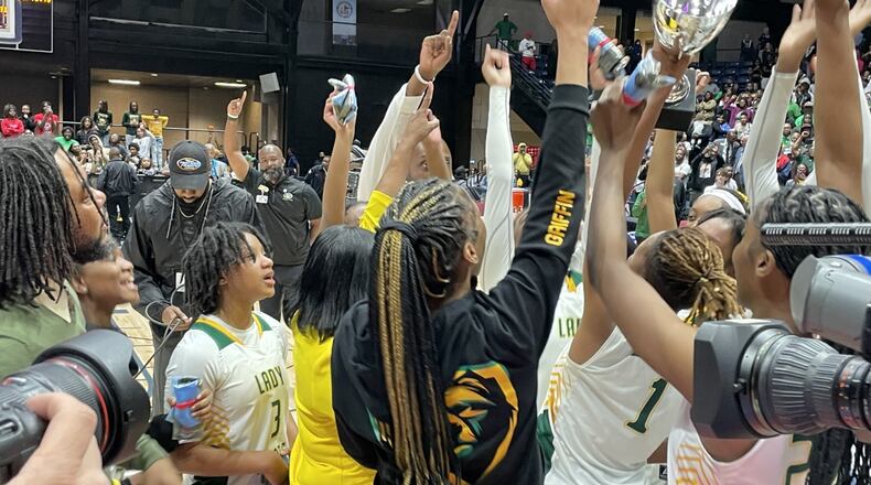 Griffin players hoist the championship trophy after defeating Baldwin 51-47 in the Class 4A girls basketball final at the Macon Coliseum on March 8, 2023.