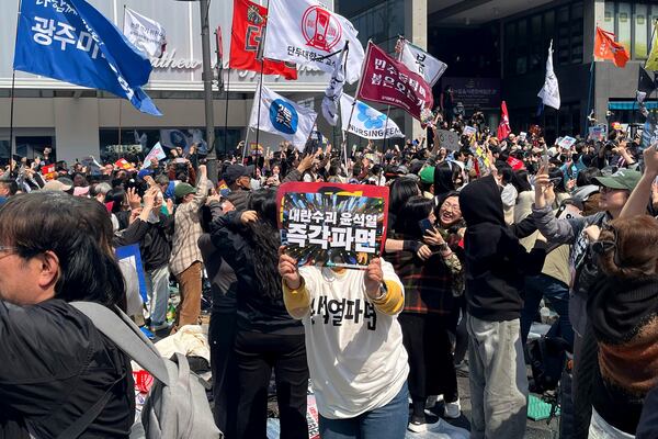People celebrate the news of President Yoon Suk Yeol's removal from office, near royal palace in downtown Seoul, South Korea, Friday, April 4, 2025. (AP Photo/Foster Klug)