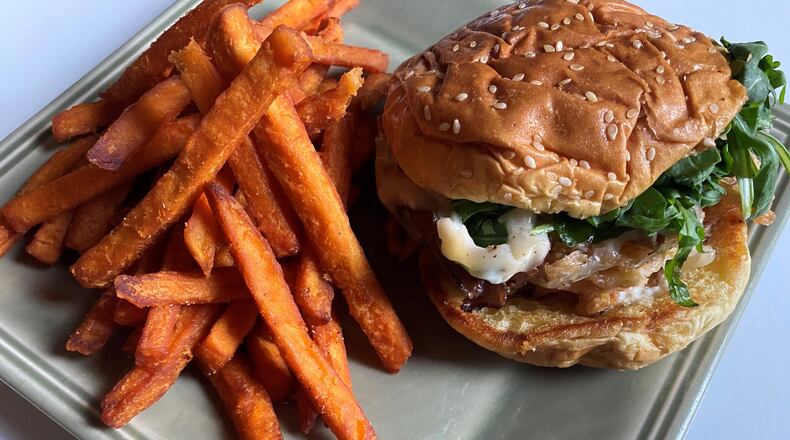 Boxcar’s Butchers Bun features shaved rib-eye, Swiss cheese, horseradish aioli and fried onions, and is served here with sweet potato fries. CONTRIBUTED BY BOB TOWNSEND