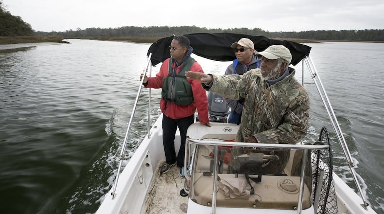 Local historian Hanif Haynes, foreground, along with Georgia state Sen. Lester Jackson, right, and local historian Jamal Touré, stops his boat near the mouth of Runaway Negro Creek near Pin Point in Savannah. Savannah-area residents want the official name of a creek on Skidaway Island to be changed from Runaway Negro Creek to Freedom Creek. (AJC Photo/Stephen B. Morton)