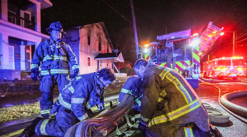A firefighter was injured battling a house fire Friday at the corner of Mayson Turner Road and Joseph E. Lowery Boulevard. JOHN SPINK / JSPINK@AJC.COM
