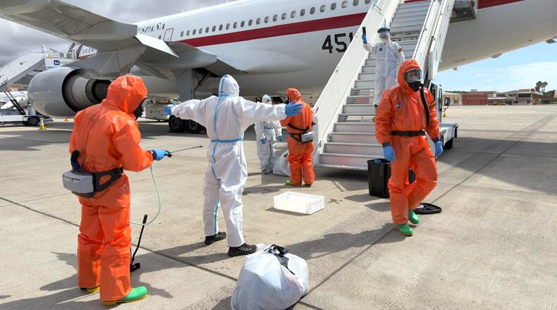 A Spanish passenger is sprayed with disinfectant by Spanish government officials before boarding a plane after disembarking from the hantavirus-stricken cruise ship MV Hondius at Tenerife airport in the Canary Islands, Spain, Sunday, May 10, 2026. (AP Photo)