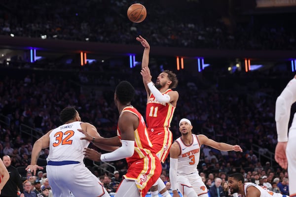 Hawks star Trae Young pulls on defenders during Monday's loss to the Knicks.