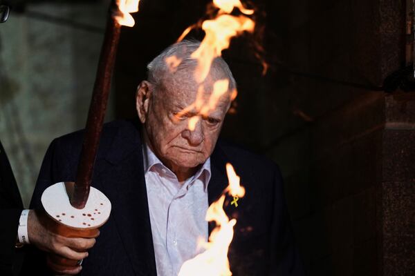 Holocaust survivor Arie Durst lights a torch during the opening ceremony of the Holocaust Remembrance Day at the Yad Vashem Holocaust Memorial Museum in Jerusalem on Wednesday, April 23, 2025. (AP Photo/Leo Correa)