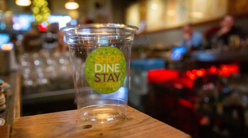 The new to-go cups sit on the bar at the Brickhouse Pub in Decatur Friday, December 10, 2021. STEVE SCHAEFER FOR THE ATLANTA JOURNAL-CONSTITUTION