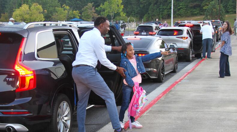 Once a month, the morning carpool at Spring Hill in Fayetteille gets a hand from the school's male volunteers. COURTESY
