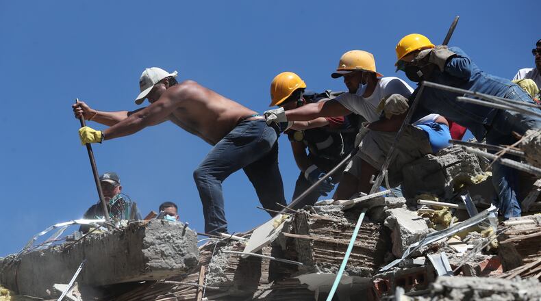 Residents and rescue workers search through the rubble after an earthquake struck Cali, Colombia, Monday, Aug. 10, 2026. (AP Photo/Santiago Saldarriaga)