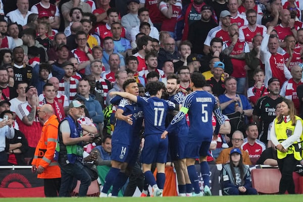 PSG players celebrate after Ousmane Dembele scored the opening goal during the Champions League semifinal first leg soccer match between Arsenal and Paris Saint-Germain at Arsenal Stadium in London, England, Tuesday, April 29, 2025. (AP Photo/Kin Cheung)