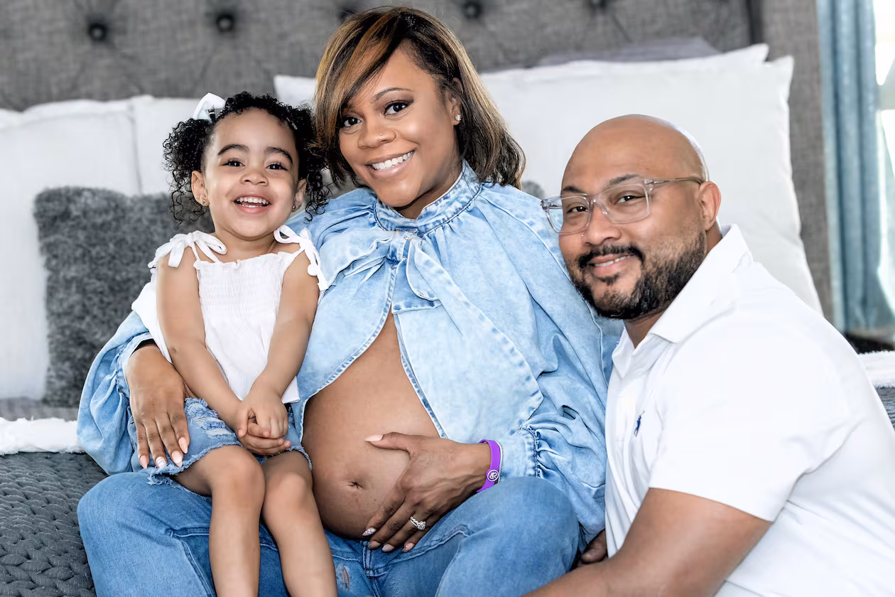 Metria Cauthen shows off her baby bump (and her birth alert bracelet) with husband, Armand Cauthen, and 3-year-old daughter, Autumn. (Aaron Moon/Courtesy Wellstar Cobb Medical Center)