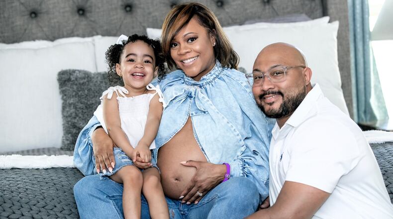 Metria Cauthen shows off her baby bump (and her birth alert bracelet) with husband, Armand Cauthen, and 3-year-old daughter, Autumn. (Aaron Moon/Courtesy Wellstar Cobb Medical Center)