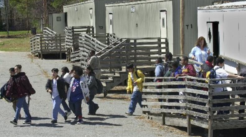Students exit temporary portable classrooms at DeKalb County’s Cary Reynolds Elementary School. DeKalb County School District and Dunwoody city officials are not saying how scores of portable classrooms at schools in the city did not receive certificates of occupancy. (AJC FILE PHOTO)
