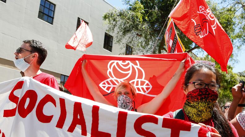 Members of the Democratic Socialists of America hold signs and flags as they march, protesting an alt-right rally on Aug.5, 2018, in downtown Berkeley, California.