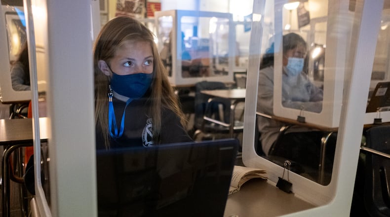 201105-Marietta-Celeste Martin works behind a plastic partition during her language arts class at Marietta Middle School on Thursday afternoon, Nov. 5, 2020. Even though there are only five students in the room during class, they all wear masks and sit behind plastic partitions. Ben Gray for the Atlanta Journal-Constitution