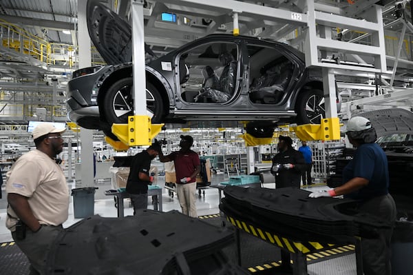 HMGMA workers check a Hyundai IONIQ 5 on the assembly line at Hyundai Motor Group Metaplant America (HMGMA) in Ellabell on Wednesday, May 6, 2026. (Hyosub Shin/AJC)