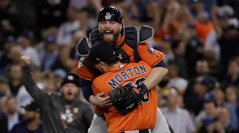 Houston Astros catcher Brian McCann leaps in the arms of starting pitcher Charlie Morton after Game 7 of baseball's World Series against the Los Angeles Dodgers Wednesday, Nov. 1, 2017, in Los Angeles. The Astros won 5-1 to win the series 4-3. (AP Photo/Matt Slocum)