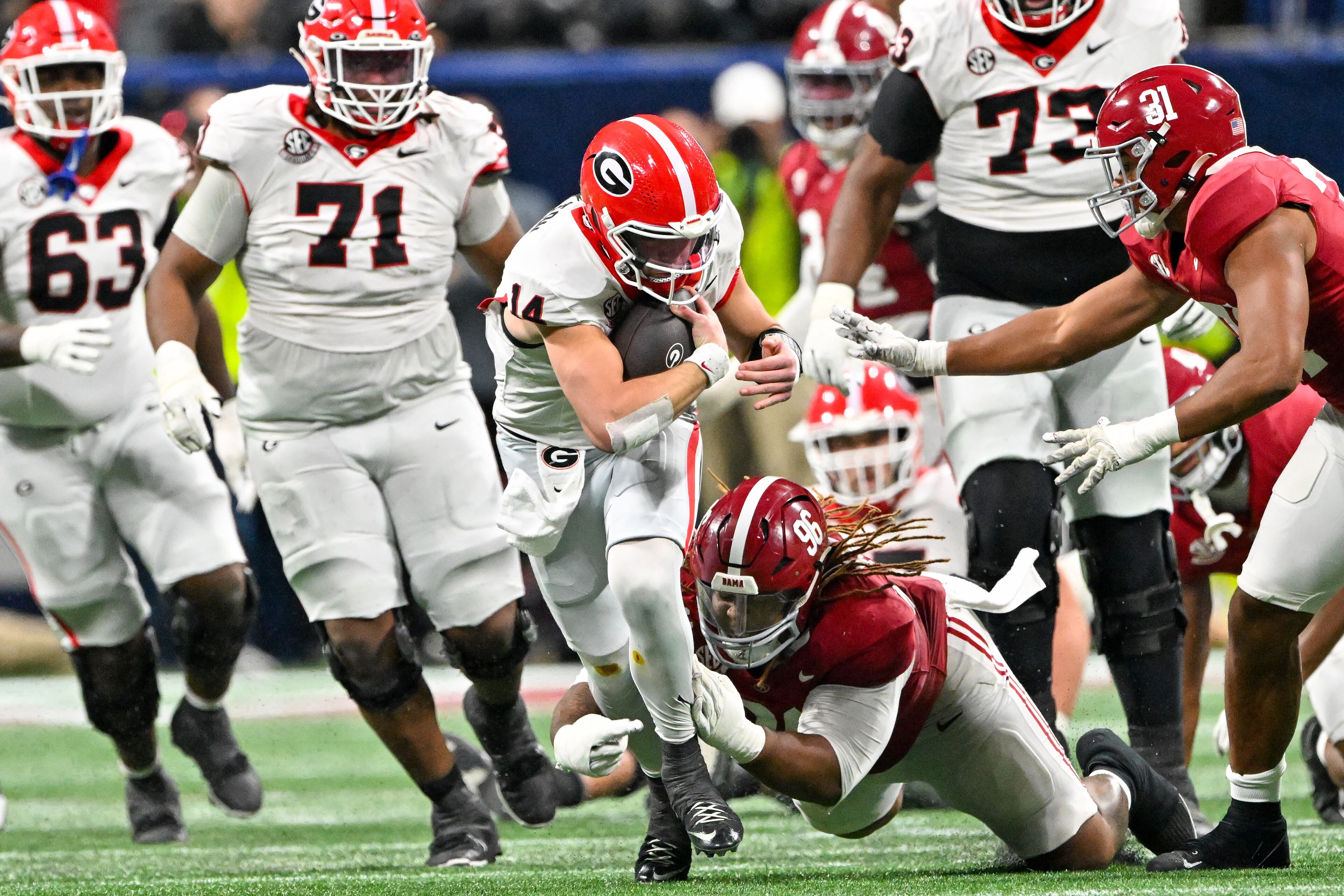 Georgia quarterback Gunner Stockton (14) runs a keeper play against Alabama defensive lineman Tim Keenan III (96) during the third quarter of the SEC Championship game at Mercedes-Benz Stadium, Saturday, Dec. 6, 2025, in Atlanta. (Hyosub Shin / AJC)