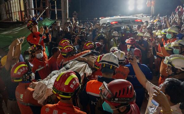 In this photo released by Xinhua News Agency, members of a China search and rescue team transfer a survivor from a collapsed Great Wall Hotel in the aftermath of an earthquake in Mandalay, Myanmar, Monday, March 31, 2025. (Cai Yang/Xinhua via AP)