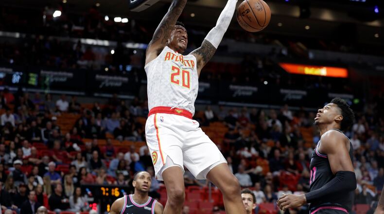 Hawks forward John Collins (20) dunks over Miami Heat center Hassan Whiteside during the first half of an NBA basketball game, Tuesday, Nov. 27, 2018, in Miami. (AP Photo/Lynne Sladky)