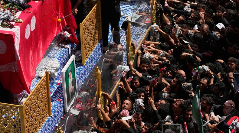 Mourners reach toward a truck carrying the coffin of Iranian Supreme Leader Ayatollah Ali Khamenei during a funeral procession in Najaf, Iraq, Wednesday, July 8, 2026. (AP Photo/Hadi Mizban)