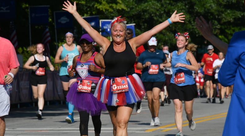 July 4, 2021 Atlanta - Runners make their way to cross the finish line during the second day of 2021 Atlanta Journal-Constitution Peachtree Road Race on Sunday, July 4, 2021. (Hyosub Shin / Hyosub.Shin@ajc.com)