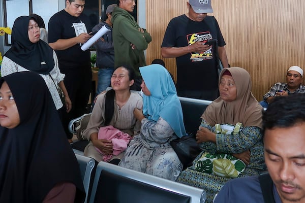 A passenger's relative weeps after a ferry carrying dozens of passengers sank near the resort island of Bali, at Ketapang Port in Bayuwangi, East Java, Indonesia, Thursday, July 3, 2025. (AP Photo/Andur)