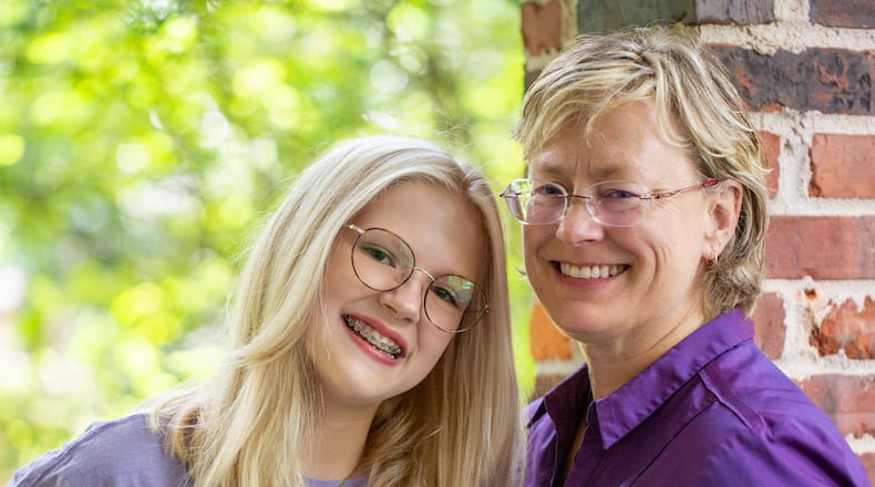 Jordan Ricks, 14, left, and her mother, Katie Ricks, are at their home Tuesday, July 27, 2021 and are pleasantly surprised to see that Druid Hills High School's freshman orientation requested students to list their preferred pronouns on their name tags. Jordan and her friends begin their freshman year in person at the high school next week. (Jenni Girtman for The Atlanta Journal-Constitution)