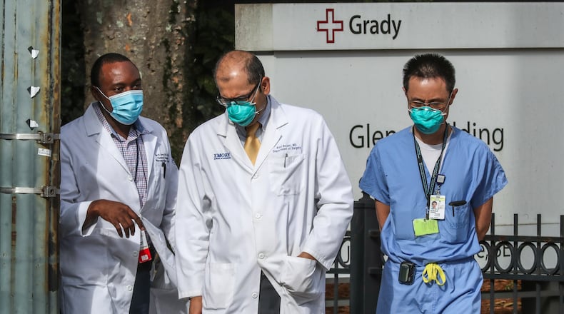 Medical workers move between buildings at Grady Memorial Hospital in downtown Atlanta on Thursday, Aug. 26, 2021 as COVID-19 cases surge in Georgia. deaths. (John Spink / John.Spink@ajc.com)