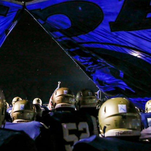The Dacula football team breaks through its banner before running onto the field for a game in Dacula. The team was given only a 41.3% chance of reaching the GHSA football playoffs. (Casey Sykes for the AJC)