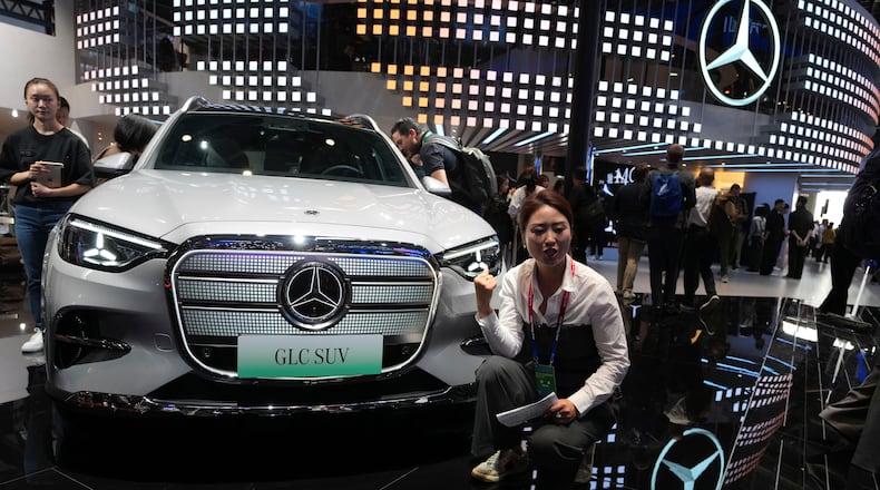 FILE - A vlogger promotes the GLC SUV at the Mercedes-Benz booth during Auto China 2026 in Beijing, on April 24, 2026. Major German carmakers saw sharp quarterly sales declines in China, as domestic demand weakened and competition heats up in the world’s biggest auto market. (AP Photo/Ng Han Guan)