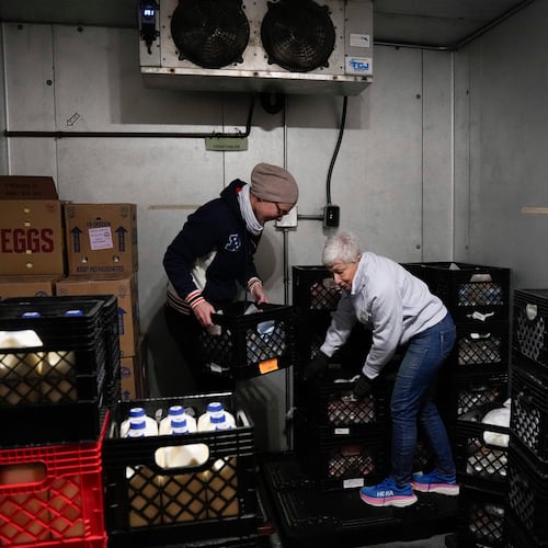 FILE - Volunteers Anja Lichtenau, left, and Marlene Rotstein organize food in a walk-in refrigerator at a non-profit food pantry, which receives federal funding to provide food and other social services, Jan. 29, 2025, in Chicago. (AP Photo/Erin Hooley, File)