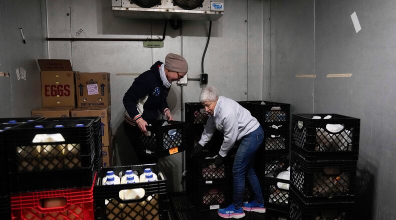 FILE - Volunteers Anja Lichtenau, left, and Marlene Rotstein organize food in a walk-in refrigerator at a non-profit food pantry, which receives federal funding to provide food and other social services, Jan. 29, 2025, in Chicago. (AP Photo/Erin Hooley, File)